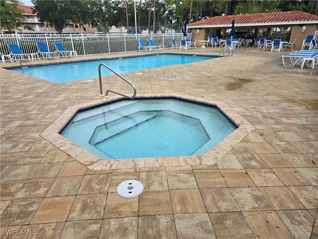 view of pool featuring a patio and a hot tub