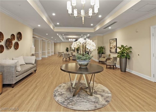 interior space with light hardwood / wood-style flooring, a tray ceiling, and ornamental molding