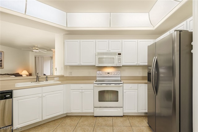 kitchen with light tile patterned flooring, sink, ceiling fan, stainless steel appliances, and white cabinets