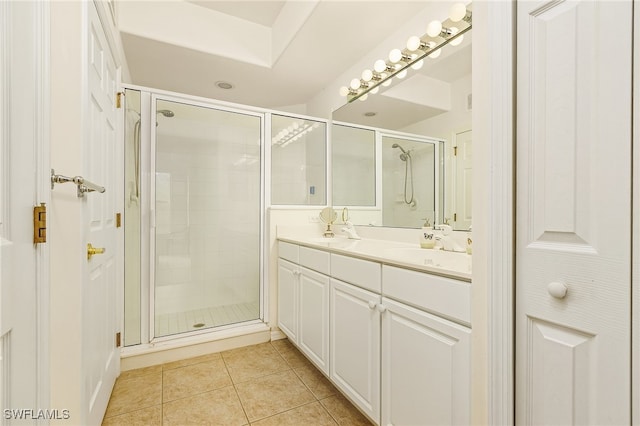 bathroom with tile patterned flooring, dual vanity, and a shower with shower door