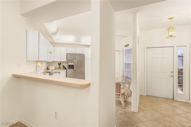 kitchen with a chandelier, white cabinetry, stainless steel fridge with ice dispenser, light tile patterned flooring, and hanging light fixtures