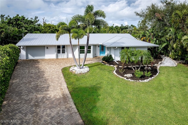 single story home featuring a front lawn and a garage