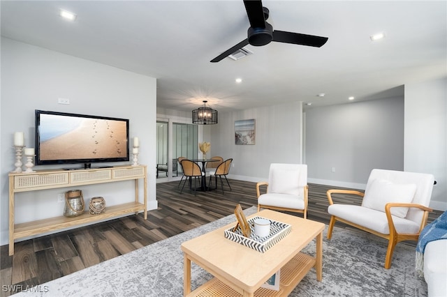 living room with dark hardwood / wood-style floors and ceiling fan with notable chandelier