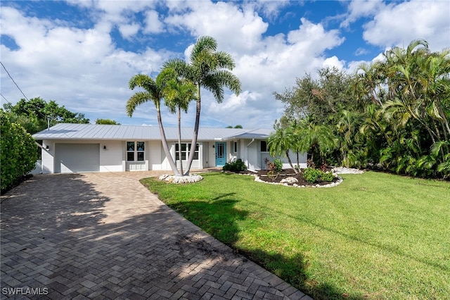 view of front of property featuring a front lawn, a garage, and a porch