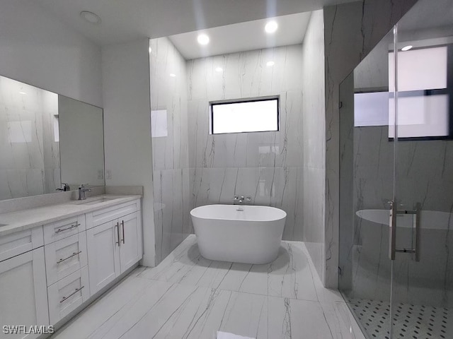 bathroom featuring tile walls, independent shower and bath, and vanity