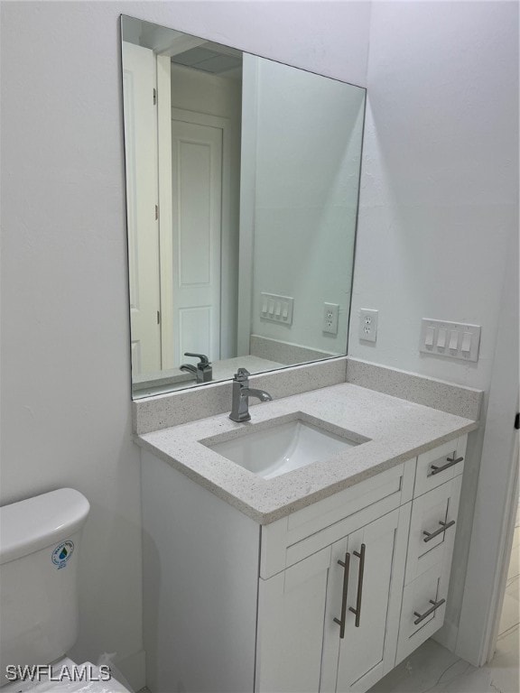 bathroom featuring toilet and vanity