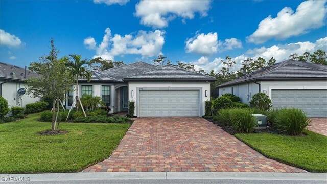 ranch-style house featuring a front lawn and a garage