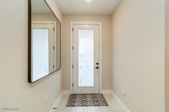 doorway to outside with light tile patterned flooring