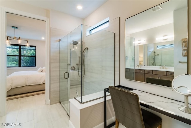 bathroom featuring vanity, a shower with shower door, and plenty of natural light