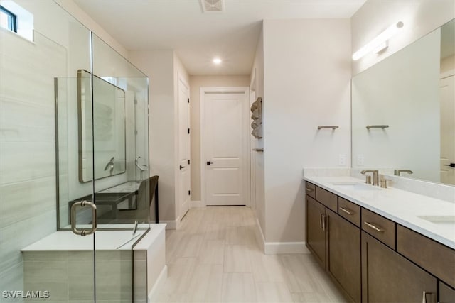 bathroom featuring a shower with door and vanity