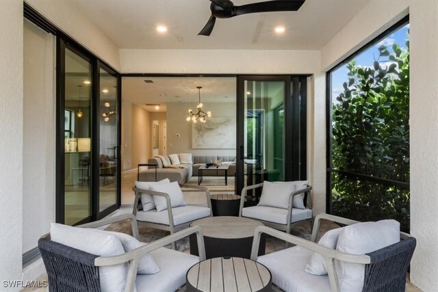 sunroom with ceiling fan with notable chandelier