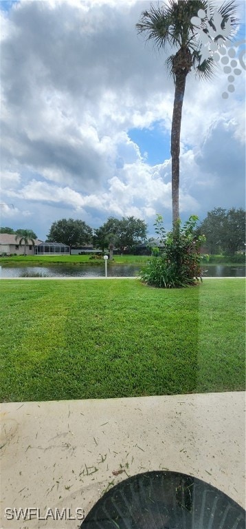 surrounding community with a lawn and a water view