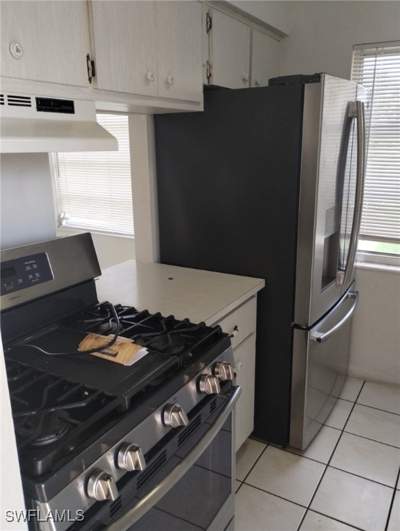 kitchen with gas range, light tile patterned floors, and extractor fan