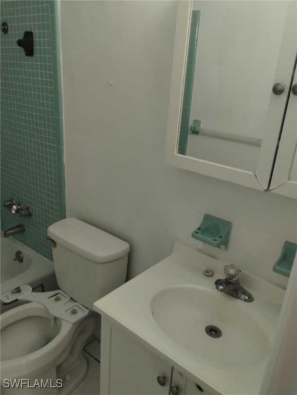 full bathroom featuring tiled shower / bath combo, vanity, and toilet