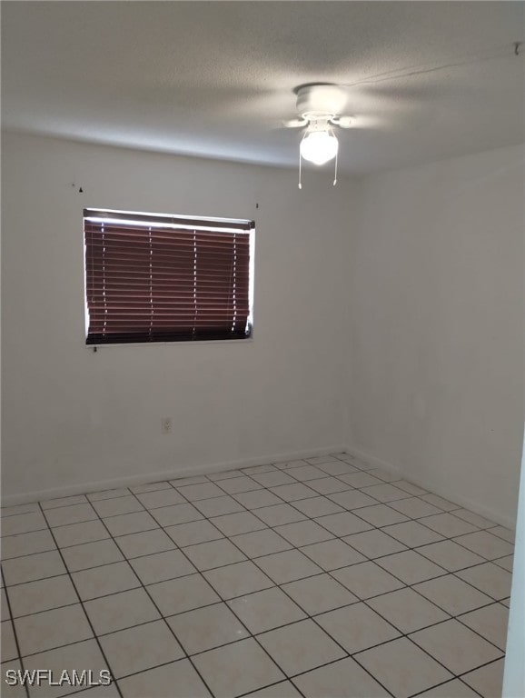 unfurnished room with ceiling fan and light tile patterned floors