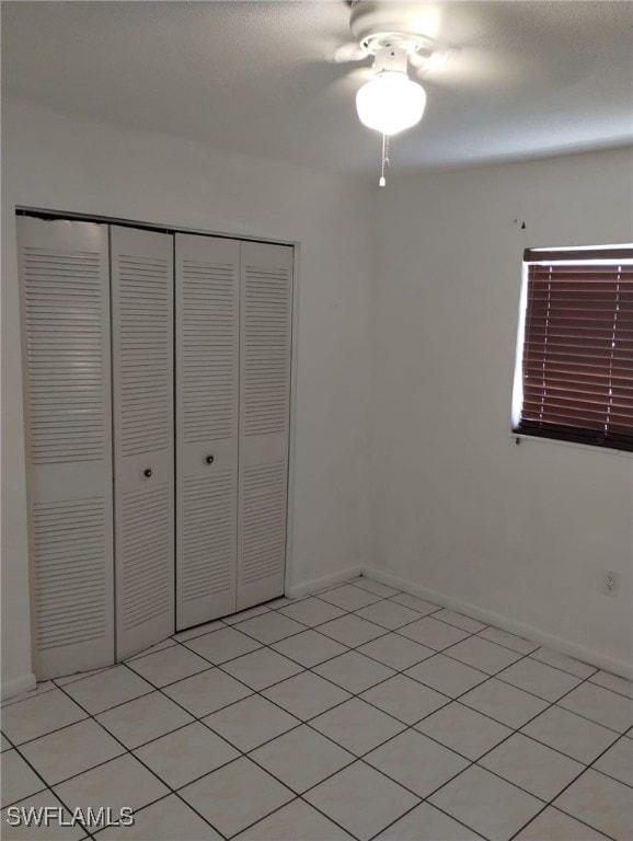 unfurnished bedroom featuring ceiling fan and a closet