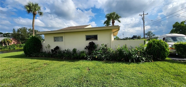 view of side of home with a yard