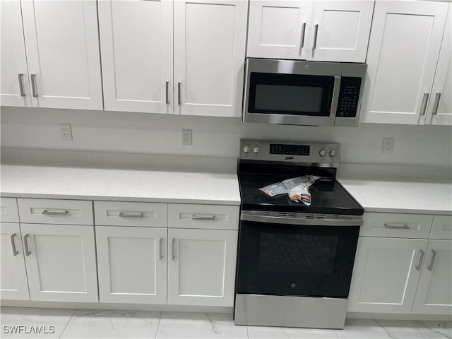 kitchen featuring appliances with stainless steel finishes and white cabinets