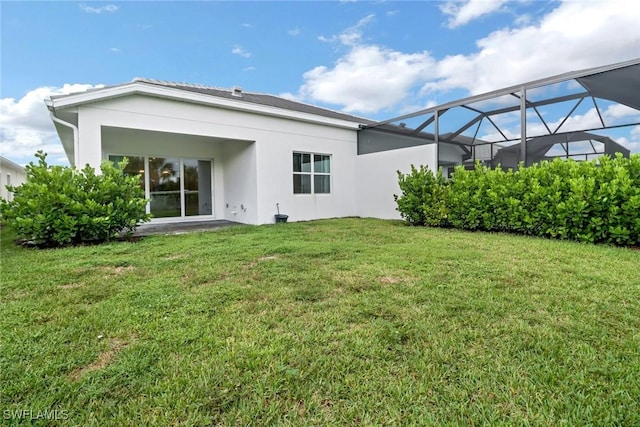 back of property with a lanai and a yard