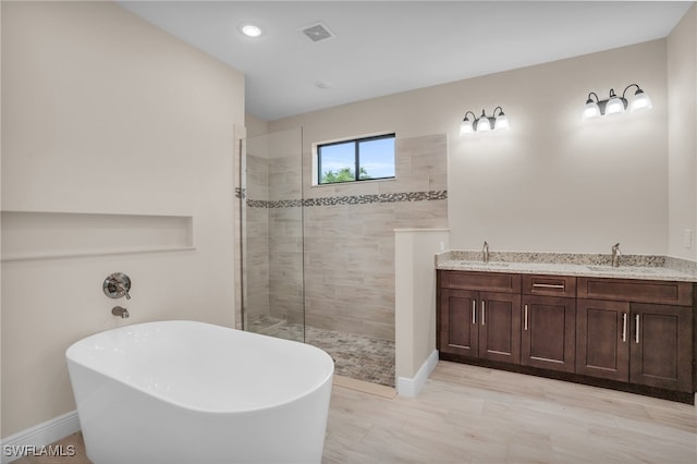 bathroom with shower with separate bathtub and vanity