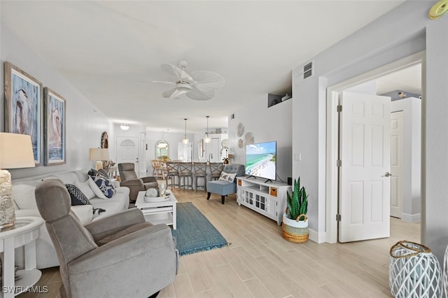 living room with ceiling fan and light wood-type flooring