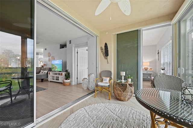 living area with ceiling fan and light wood-type flooring