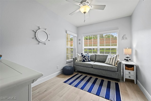 living room featuring ceiling fan and light hardwood / wood-style floors