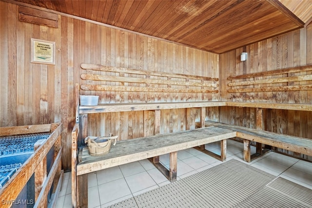 view of sauna with tile patterned flooring, wooden walls, and wood ceiling