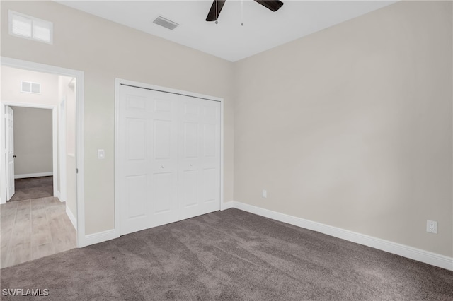 unfurnished bedroom featuring light colored carpet, a closet, and ceiling fan