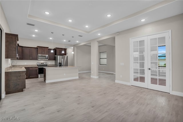 kitchen with a center island, sink, appliances with stainless steel finishes, light hardwood / wood-style flooring, and french doors