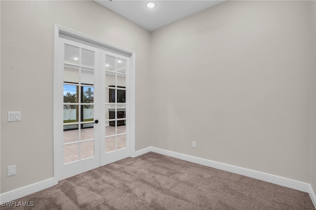 carpeted empty room featuring french doors