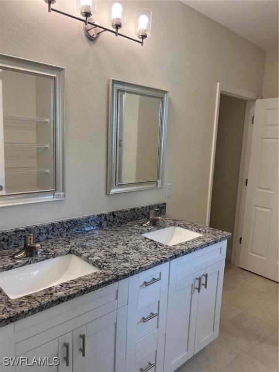 bathroom with tile patterned flooring, vanity, and a chandelier