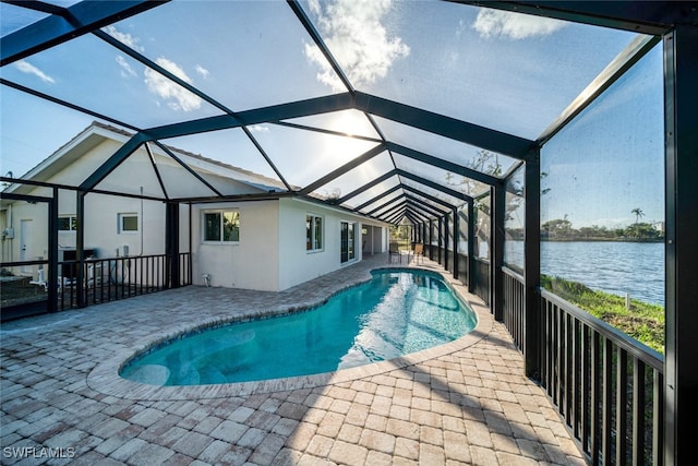 view of swimming pool with a lanai, a water view, and a patio area