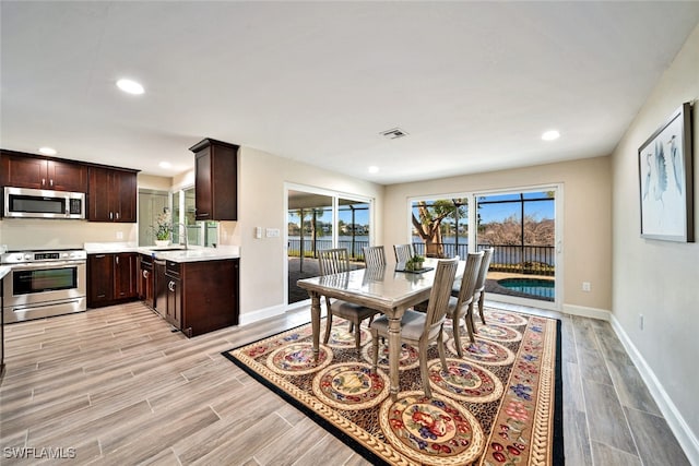 dining room featuring sink and light hardwood / wood-style flooring