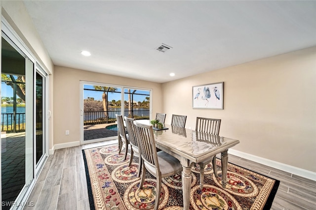 dining room with a water view and hardwood / wood-style flooring