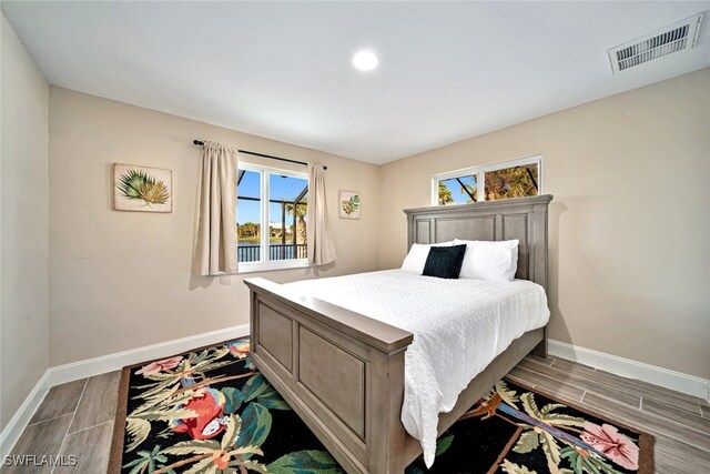 bedroom with hardwood / wood-style flooring and multiple windows