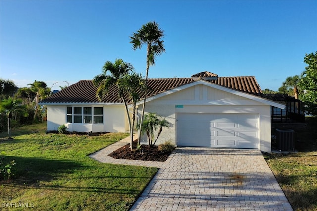 view of front facade featuring central AC unit, a garage, and a front lawn