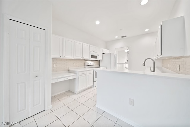 kitchen with kitchen peninsula, light tile patterned floors, white cabinets, white appliances, and tasteful backsplash