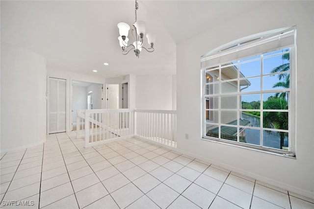 unfurnished room featuring light tile patterned flooring and a notable chandelier