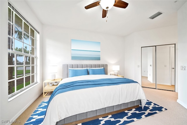 carpeted bedroom with a closet and ceiling fan