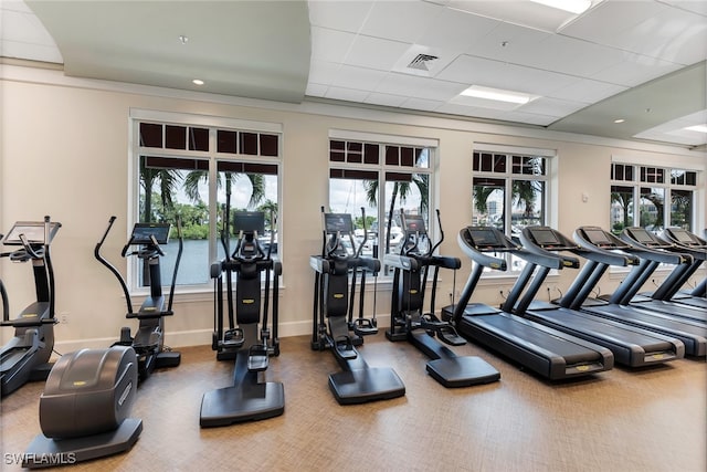 workout area with a drop ceiling and a wealth of natural light