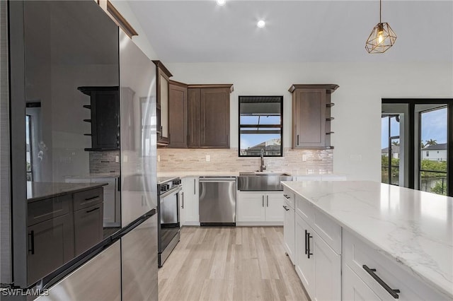 kitchen with dark brown cabinetry, sink, range, stainless steel dishwasher, and white cabinets