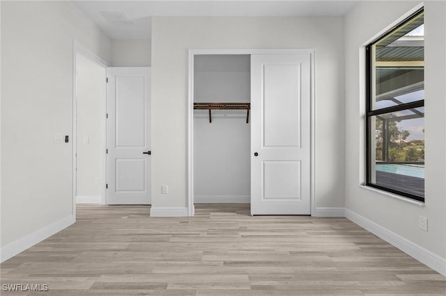 unfurnished bedroom featuring a closet and light hardwood / wood-style flooring