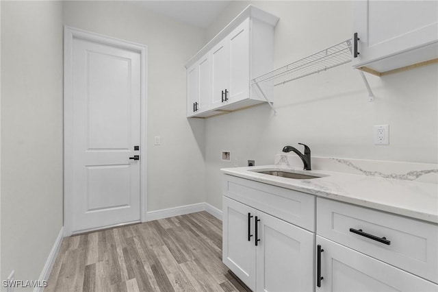 laundry room with sink, cabinets, washer hookup, light hardwood / wood-style floors, and electric dryer hookup