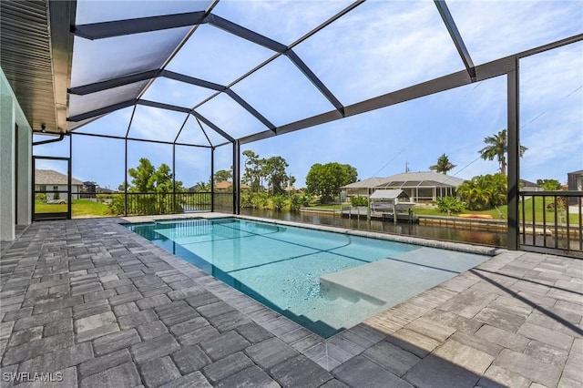 view of swimming pool with a water view, glass enclosure, and a patio area