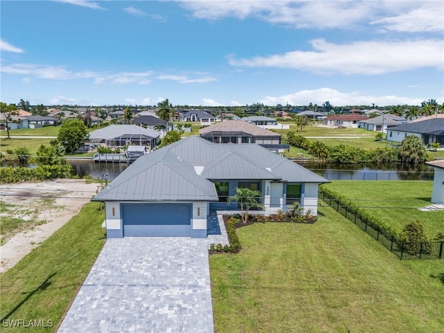 view of front of home featuring a water view, a garage, and a front lawn