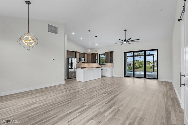 unfurnished living room featuring ceiling fan, high vaulted ceiling, and light hardwood / wood-style floors