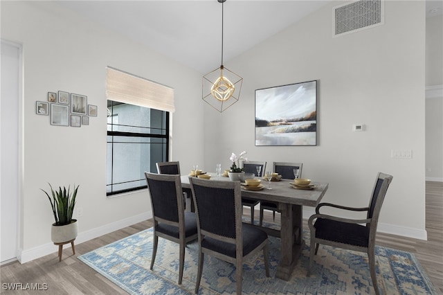 dining space with wood-type flooring and lofted ceiling