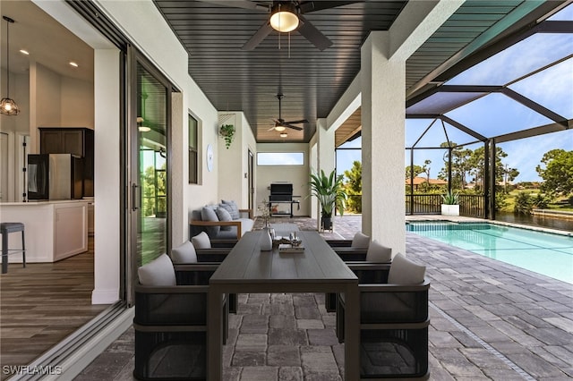 exterior space with a lanai, a patio area, ceiling fan, and a bar