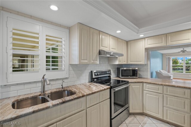 kitchen featuring appliances with stainless steel finishes, decorative backsplash, sink, light stone countertops, and light tile patterned floors